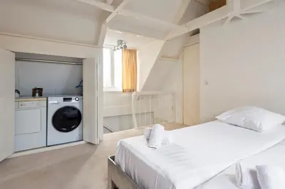 a bedroom with a bed and a washing machine at Zandvoort Zenith - Beautiful Apartment in Zandvoort
