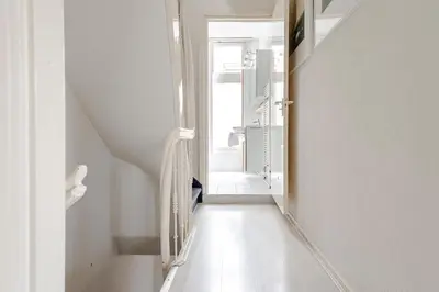 a hallway with white walls and a white staircase at Zandvoort Zenith - Beautiful Apartment in Zandvoort