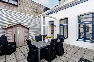 a patio with a wooden table and chairs at Zandvoort Zenith - Beautiful Apartment in Zandvoort