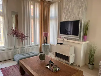 a living room with a tv and a couch and a table at Zandvoort Zenith - Beautiful Apartment in Zandvoort