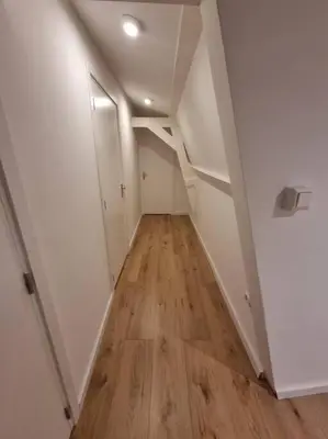 an empty hallway with white walls and wood floors at Apartment City Center Gouda in Gouda