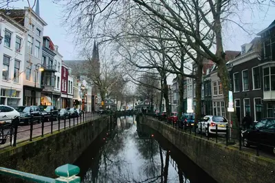 a city street with cars parked next to a canal at Apartment City Center Gouda in Gouda