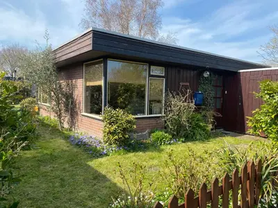 a small house in a yard with a fence at Casa Calida in Warmenhuizen