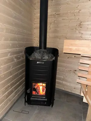 a black stove in a room with a brick wall at Wellness at Sea in Egmond aan Zee