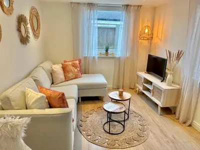 a living room with a couch and a tv at Wellness at Sea in Egmond aan Zee