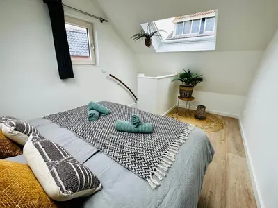 a bedroom with a bed with blue towels on it at Wellness at Sea in Egmond aan Zee