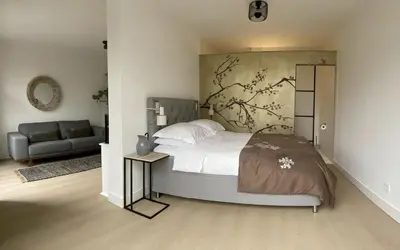 a bedroom with a large bed and a couch at The East Wing Bloemendaal in Bloemendaal
