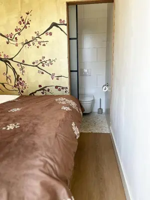 a bedroom with a bed and a bathroom with a shower at The East Wing Bloemendaal in Bloemendaal