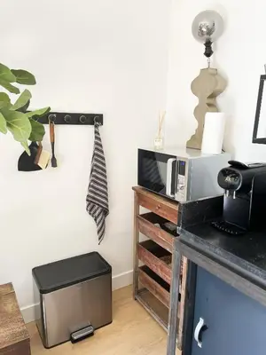 a room with a counter with a microwave and a table at The East Wing Bloemendaal in Bloemendaal