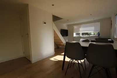 a living room with a table and two chairs at Have a nice stay! - Zomerhuis Benita's met parkeer plaats in Noordwijk aan Zee