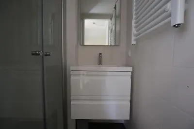 a bathroom with a white sink and a mirror at Have a nice stay! - Zomerhuis Benita's met parkeer plaats in Noordwijk aan Zee