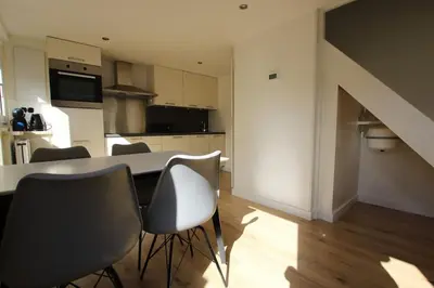 a kitchen with a table and chairs in a room at Have a nice stay! - Zomerhuis Benita's met parkeer plaats in Noordwijk aan Zee