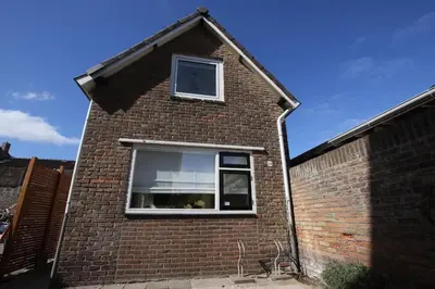 a brick house with a window on the side at Have a nice stay! - Zomerhuis Benita's met parkeer plaats in Noordwijk aan Zee
