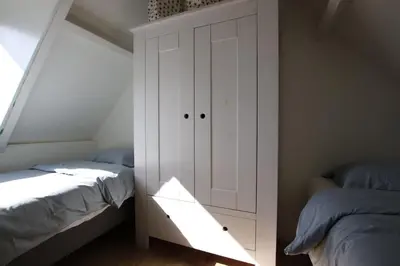 a bedroom with two beds and a white cabinet at Have a nice stay! - Zomerhuis Benita's met parkeer plaats in Noordwijk aan Zee