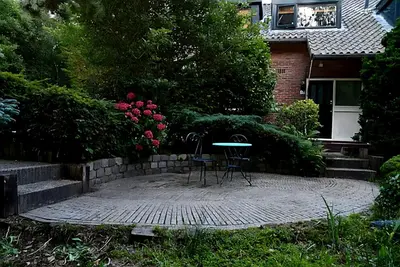 two chairs and a table in front of a house at Villa in the forest of Amsterdam with Pool in Velsen-Zuid