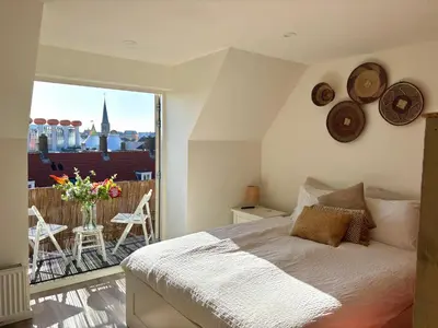 a bedroom with a bed and a balcony with a view at Maun Apartment in Zandvoort