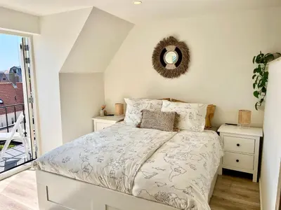 a bedroom with a bed and a mirror on the wall at Maun Apartment in Zandvoort