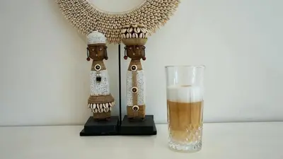 a glass of beer next to a table with a lamp at Maun Apartment in Zandvoort