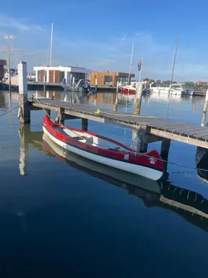 a boat is docked next to a dock at Houseboat De Amstel in Monnickendam
