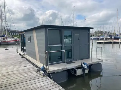 a small house on a dock on the water at Houseboat De Amstel in Monnickendam