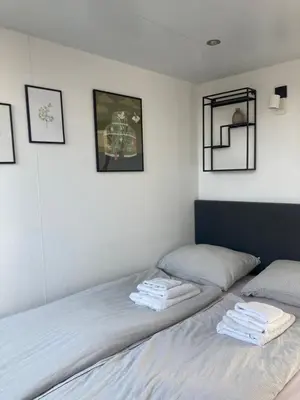 a bedroom with two beds with towels on them at Houseboat De Amstel in Monnickendam