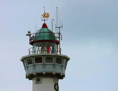a green and white lighthouse with a clock on it at Gelijkvloers Vakantieappartement 150m van Strand Egmond aan Zee in Egmond aan Zee