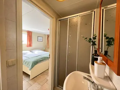 a bathroom with a bed and a tub and a sink at Studio aan Zee op 150 Meter van Strand in Egmond aan Zee