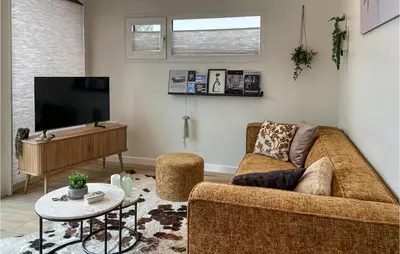 a living room with a couch and a tv at Stunning House In Spakenburg in Spakenburg