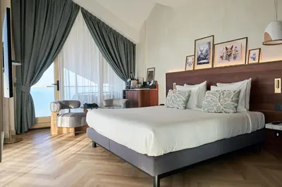 a bedroom with a large bed and a large window at Boutique Hotel Blendin Bloemendaal aan Zee in Bloemendaal Aan Zee