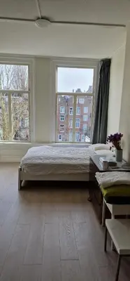 a bedroom with a large bed and two windows at Frank’s and Chong’s excellent location in Amsterdam