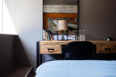 a bedroom with a desk with a lamp and a bed at Rooms25 in Amsterdam