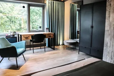 a room with a desk and chairs and windows at Rooms25 in Amsterdam