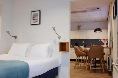 a bedroom with a bed and a kitchen with a table at Rooms25 in Amsterdam