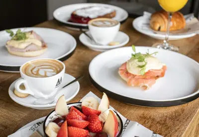 a table with plates of food and cups of coffee at Rooms25 in Amsterdam