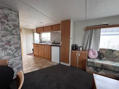 a living room with a kitchen and a couch at Retro Stacaravans in Warmond