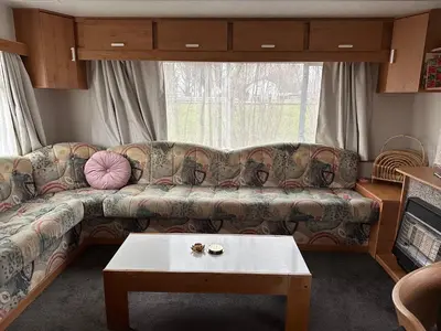 a living room with a couch and a table at Retro Stacaravans in Warmond