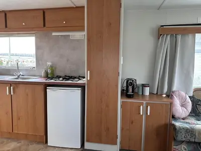 a kitchen with a sink and a stove top oven at Retro Stacaravans in Warmond
