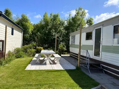 a picnic table in front of a trailer at Retro Stacaravans in Warmond
