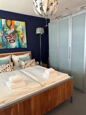 a bedroom with a large bed with a blue wall at Apartment Fleurette in Zandvoort