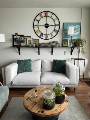 a living room with a couch and a clock on the wall at Apartment Fleurette in Zandvoort