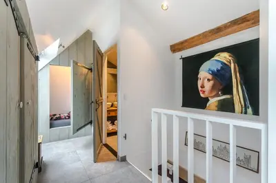 a hallway with a painting of a woman with a hijab at Luxury apartment in farmhouse near Amsterdam in Ilpendam