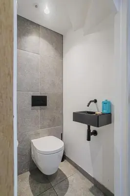 a bathroom with a white toilet and a sink at Luxury apartment in farmhouse near Amsterdam in Ilpendam