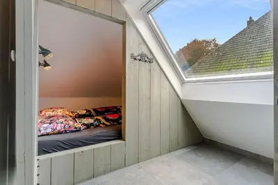 a small room with a bed in a window at Luxury apartment in farmhouse near Amsterdam in Ilpendam
