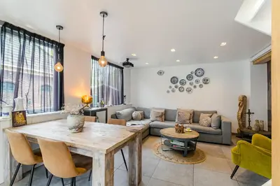 a living room with a table and a couch at Luxury apartment in farmhouse near Amsterdam in Ilpendam