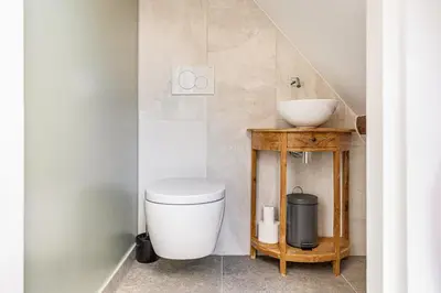 a bathroom with a toilet and a sink at Authentic apartment in farmhouse near Amsterdam in Ilpendam