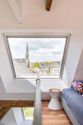 a large window with a view of a city at Authentic apartment in farmhouse near Amsterdam in Ilpendam