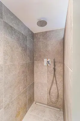 a bathroom with a shower with a shower head at Authentic apartment in farmhouse near Amsterdam in Ilpendam
