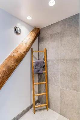 a wooden ladder next to a wall with a beam at Authentic apartment in farmhouse near Amsterdam in Ilpendam
