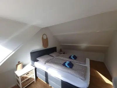 a bedroom with a bed with blue pillows on it at Blue Wave in Egmond aan Zee