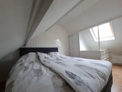 a bedroom with a large bed in a attic at Blue Wave in Egmond aan Zee